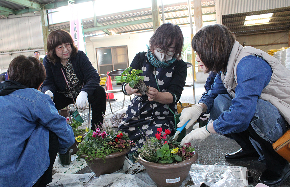 会話しながら寄せ植えを楽しむ部員